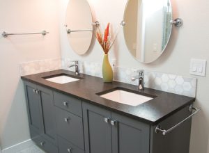 New construction of a bathroom with a double vanity an decorations. Bathroom image of sinks, mirrors, counter, and storage cabinets.