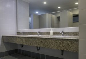 Faucets with washbasin on granite counter in men restroom